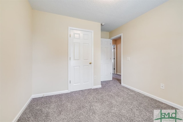 empty room featuring carpet and a textured ceiling