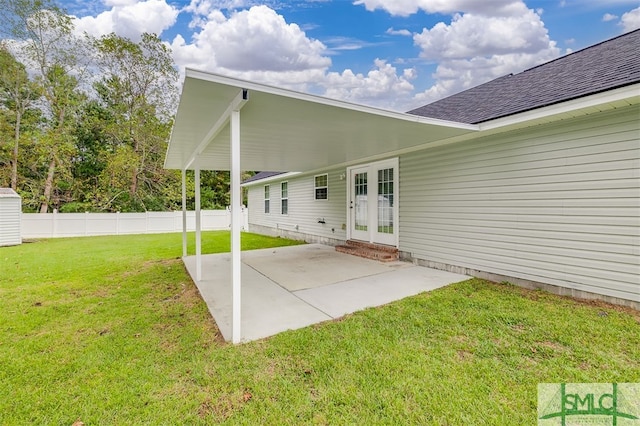 rear view of house with french doors, a lawn, and a patio area