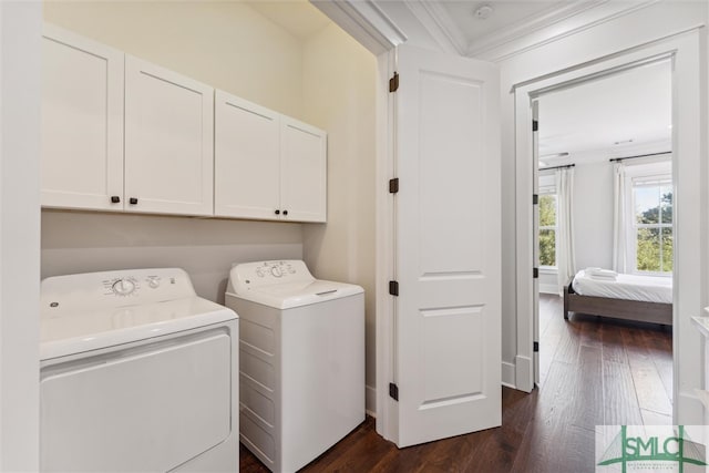 laundry area with dark wood-type flooring, independent washer and dryer, cabinets, and ornamental molding