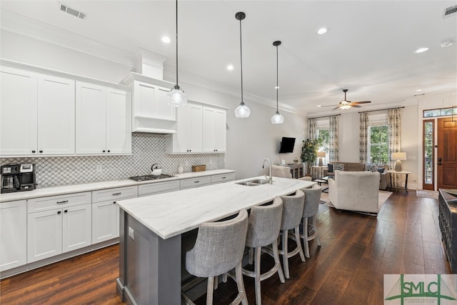 kitchen with pendant lighting, dark hardwood / wood-style floors, sink, and white cabinetry