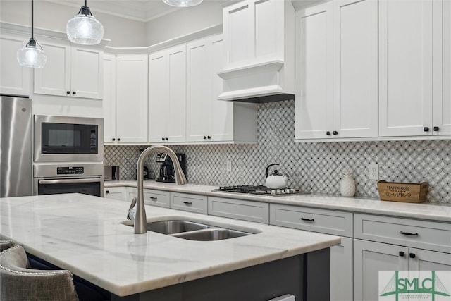 kitchen featuring white cabinets, appliances with stainless steel finishes, sink, and light stone counters