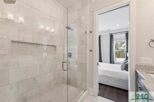 bathroom with hardwood / wood-style floors, a shower with door, and vanity