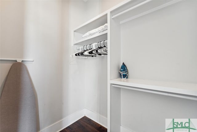 walk in closet with dark hardwood / wood-style flooring