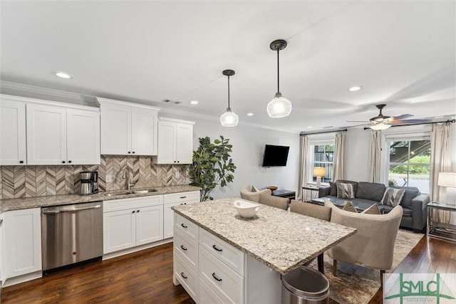 kitchen with dark hardwood / wood-style floors, sink, hanging light fixtures, white cabinets, and stainless steel dishwasher