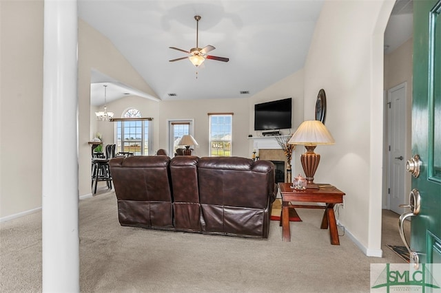 carpeted living room with ceiling fan with notable chandelier, lofted ceiling, and a fireplace