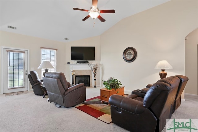 carpeted living room featuring ceiling fan, vaulted ceiling, and a tile fireplace