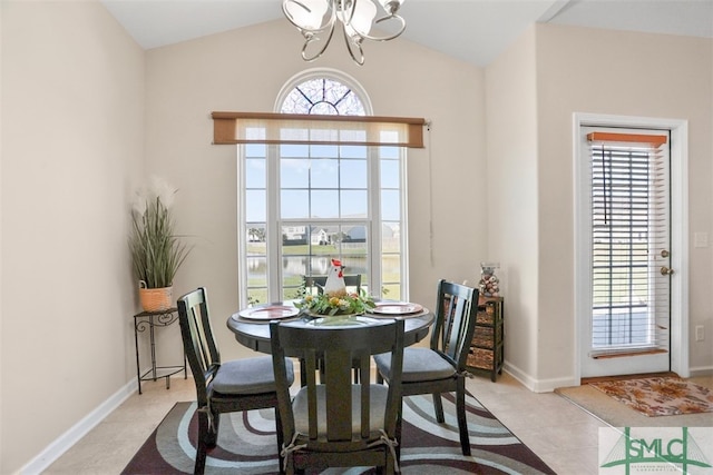 tiled dining space featuring an inviting chandelier and vaulted ceiling