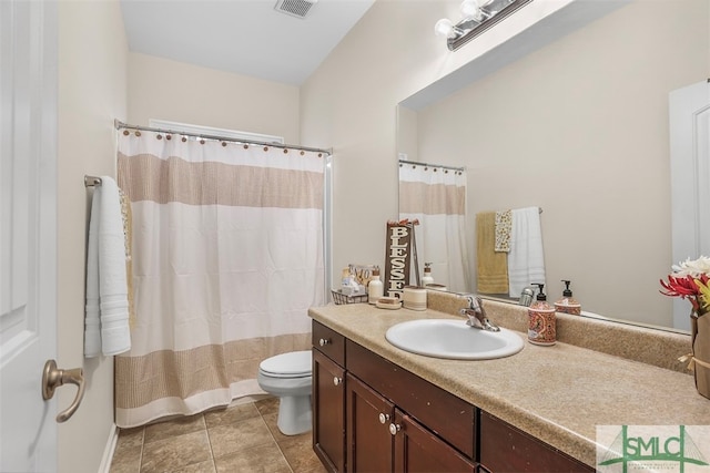 bathroom with tile patterned floors, vanity, walk in shower, and toilet