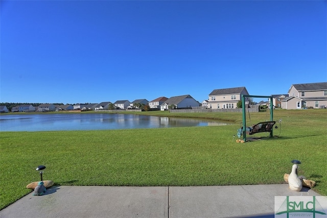 view of home's community with a water view and a lawn