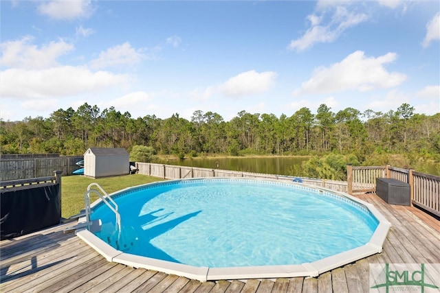 view of swimming pool with a shed, a lawn, and a deck with water view