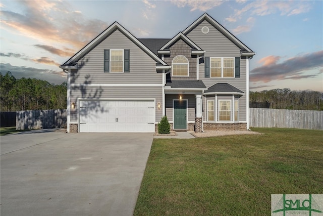 view of front of home featuring a garage and a yard