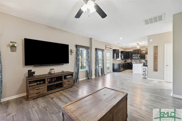 living room featuring light hardwood / wood-style floors and ceiling fan