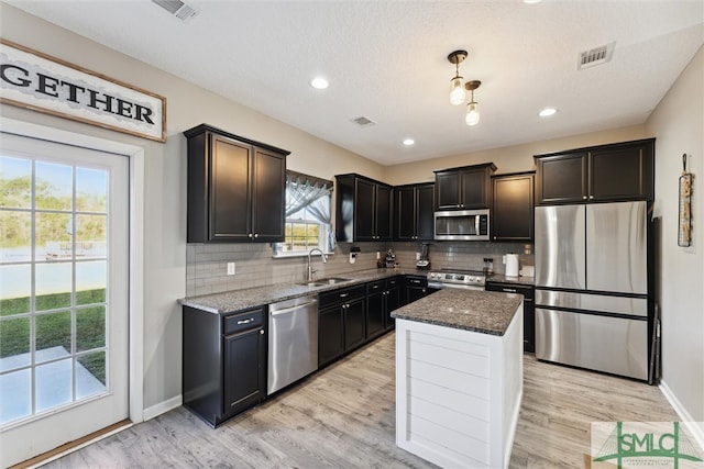 kitchen featuring stainless steel appliances, plenty of natural light, sink, and light wood-type flooring