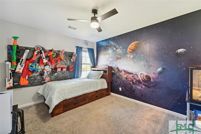 carpeted bedroom featuring ceiling fan and a textured ceiling