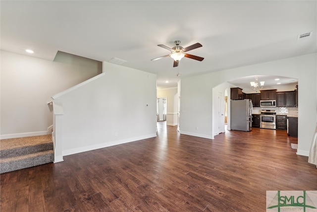 unfurnished living room featuring ceiling fan with notable chandelier and dark hardwood / wood-style flooring