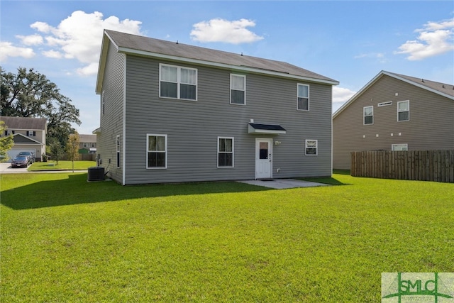 rear view of property with a lawn and central air condition unit