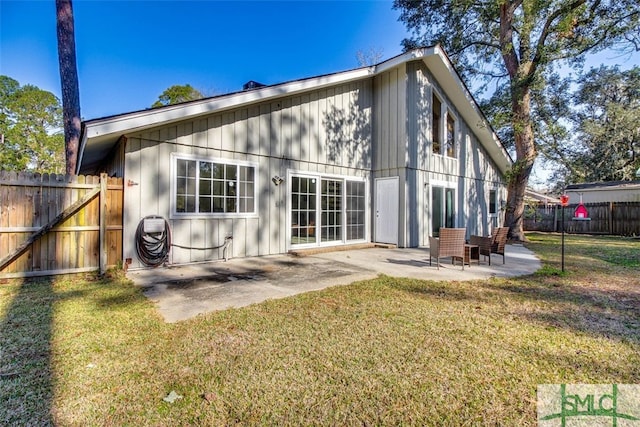 back of house featuring a lawn and a patio area