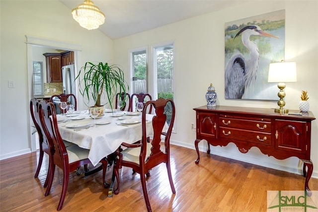 dining room featuring light wood-type flooring and a chandelier