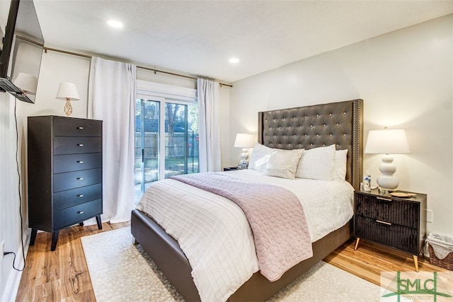 bedroom with access to exterior and light hardwood / wood-style flooring