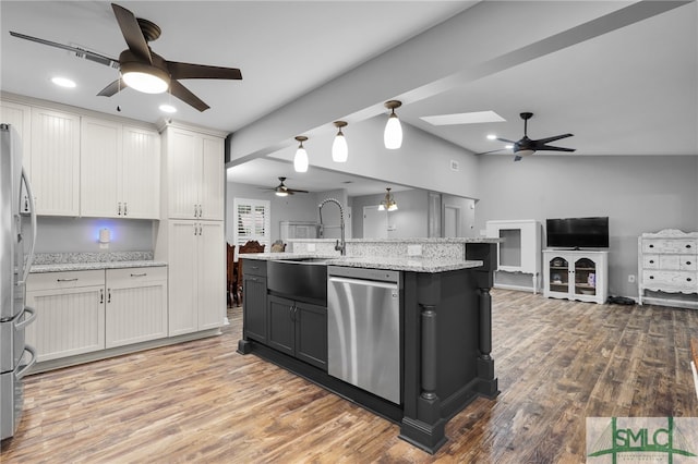 kitchen with an island with sink, stainless steel appliances, hardwood / wood-style flooring, sink, and white cabinetry