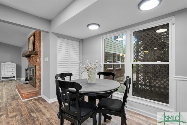 dining area with hardwood / wood-style flooring and a fireplace