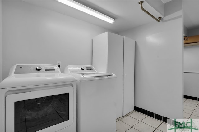 laundry area with washer and clothes dryer and light tile patterned floors