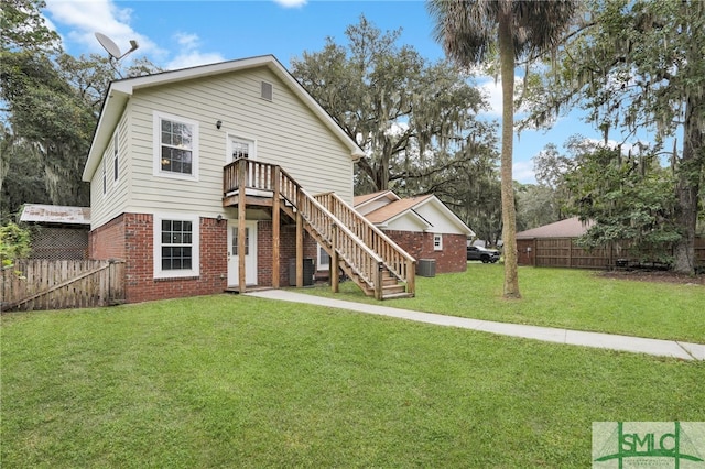 rear view of house with a yard and a deck