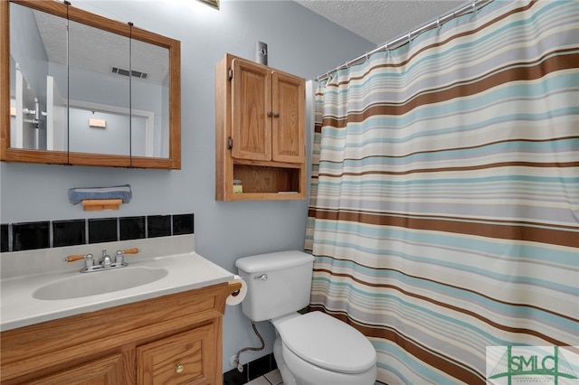 bathroom featuring vanity, toilet, curtained shower, and a textured ceiling