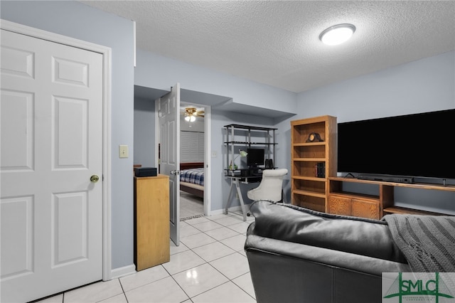 tiled living room featuring ceiling fan and a textured ceiling