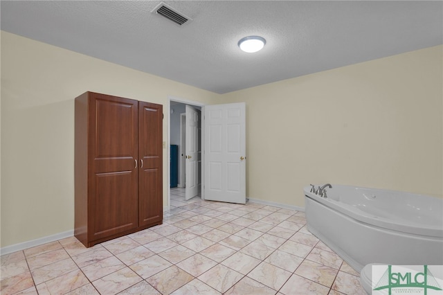 bathroom with a tub and a textured ceiling