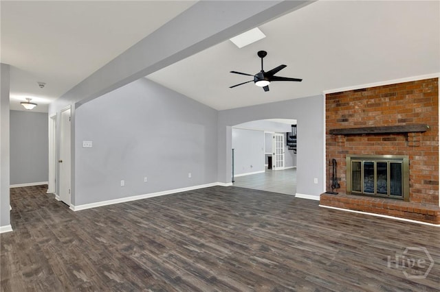 46 River Oaks Rd, Savannah, GA 31410 - unfurnished living room featuring dark wood finished floors, a ceiling fan, lofted ceiling, baseboards, and arched walkways