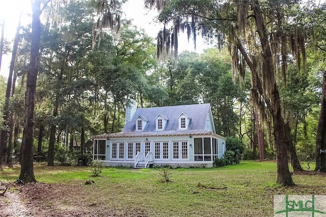 back of house featuring a yard and a sunroom