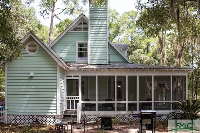 rear view of house featuring a sunroom