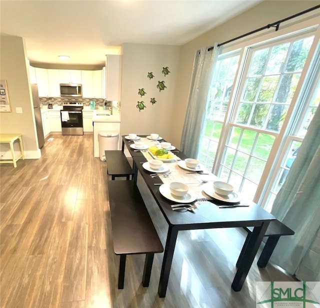 dining area featuring sink and light hardwood / wood-style flooring