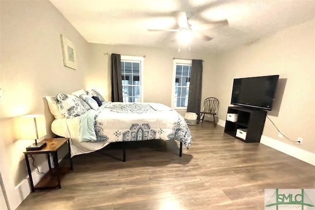 bedroom with ceiling fan, hardwood / wood-style floors, and a textured ceiling