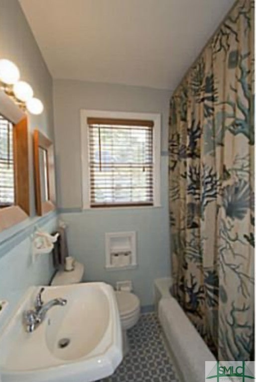 full bathroom with shower / bath combo with shower curtain, sink, and toilet