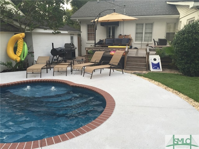 view of swimming pool featuring area for grilling and a patio area