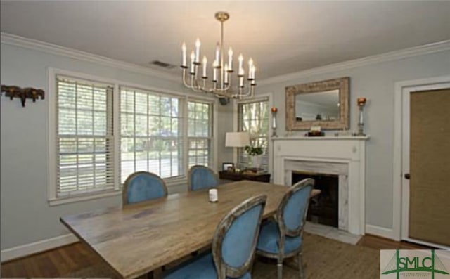 dining space with an inviting chandelier, crown molding, and hardwood / wood-style floors