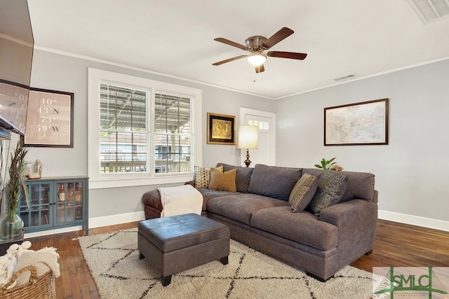 living room with dark wood-type flooring, crown molding, and ceiling fan