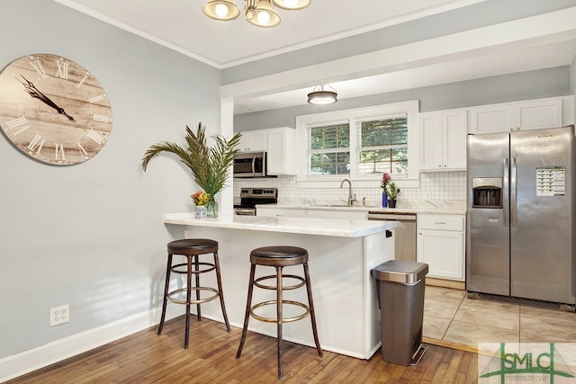 kitchen featuring stainless steel appliances, light wood-type flooring, and white cabinetry