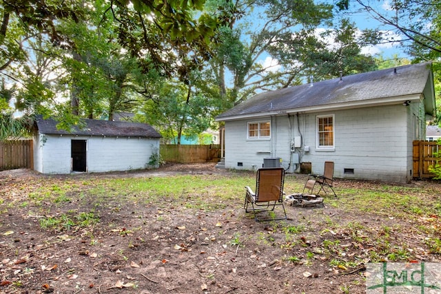 rear view of property with central AC and an outdoor fire pit