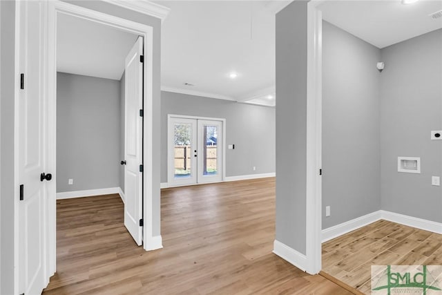 foyer entrance with crown molding, french doors, and light hardwood / wood-style floors