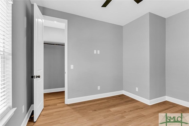 unfurnished bedroom with ceiling fan, a closet, and light hardwood / wood-style flooring