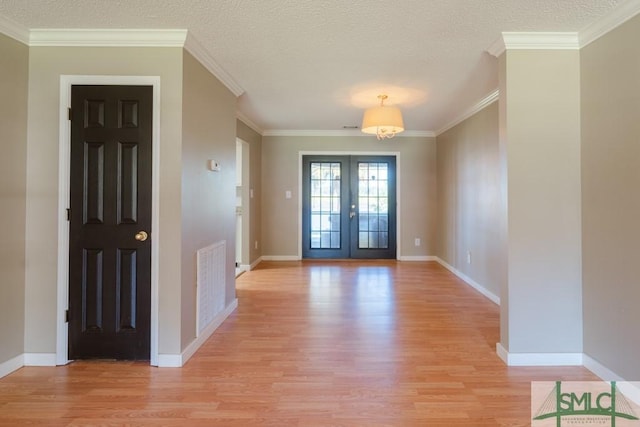 159 E 1st St, Midway, GA 31320 - entrance foyer with light wood-style floors, french doors, and crown molding