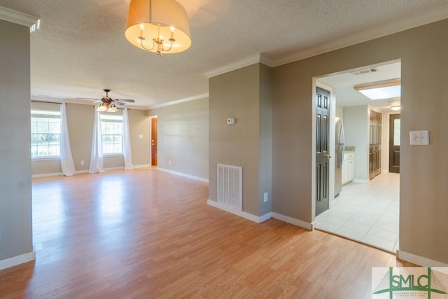 159 E 1st St, Midway, GA 31320 - unfurnished room with ornamental molding, light wood-style floors, a textured ceiling, a ceiling fan, and a chandelier