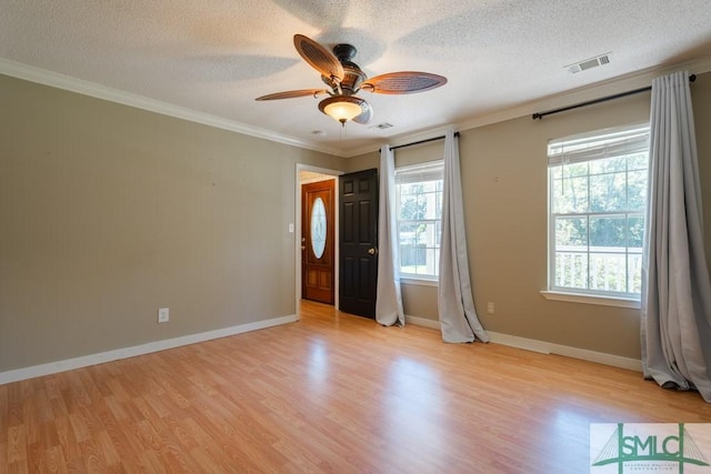159 E 1st St, Midway, GA 31320 - empty room featuring a textured ceiling, light wood finished floors, ceiling fan, and ornamental molding
