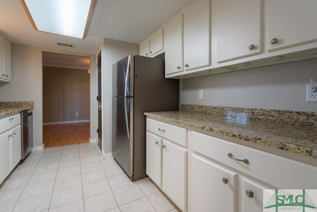 159 E 1st St, Midway, GA 31320 - kitchen with stainless steel appliances, white cabinets, and light tile patterned floors