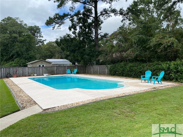 view of swimming pool with a diving board, a yard, and a patio