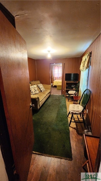 bedroom with wood walls and hardwood / wood-style flooring