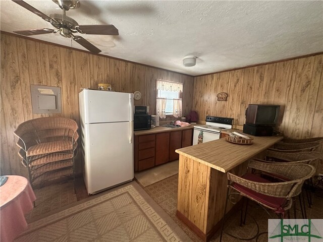 kitchen featuring ceiling fan, sink, kitchen peninsula, white appliances, and a textured ceiling